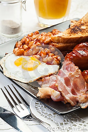 Full English breakfast with bacon, sausage, egg, baked beans and