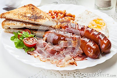 Full English breakfast with bacon, sausage, fried egg and baked beans