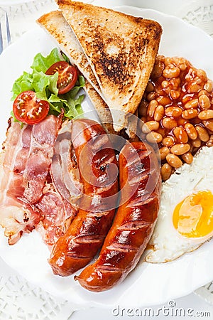 Full English breakfast with bacon, sausage, fried egg and baked beans