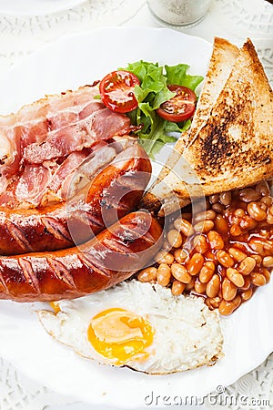 Full English breakfast with bacon, sausage, fried egg and baked beans