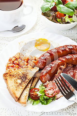 Full English breakfast with bacon, sausage, fried egg and baked beans