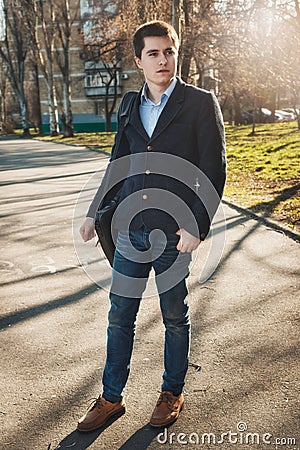 Full-lenght portrait of young man wearing a casual black jacket and jeans