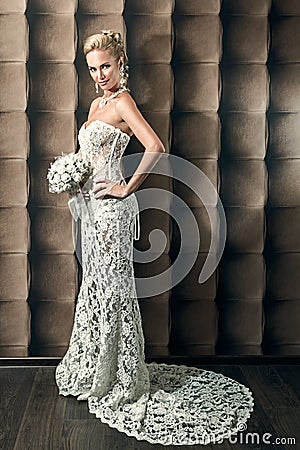 Full length portrait of a beautiful bride holding bouquet