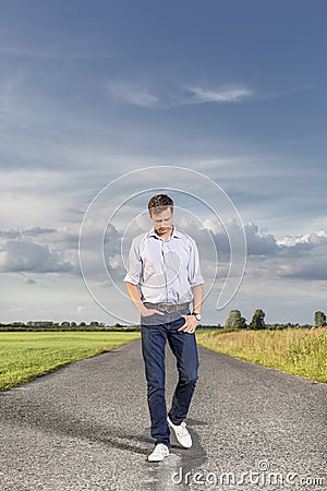 Full length of young man walking on empty rural road