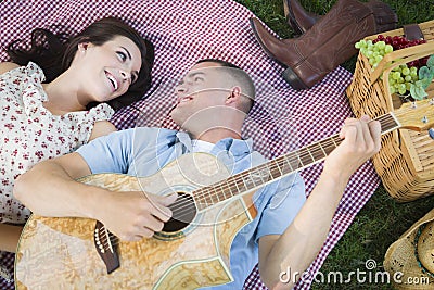 Fun Mixed Race Couple Playing Guitar and Singing