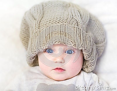 Funny baby in a huge knitted hat