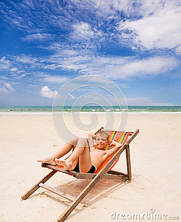 Funny boy in beach chair on the beach