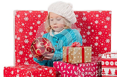 Funny girl around christmas boxes with red ball