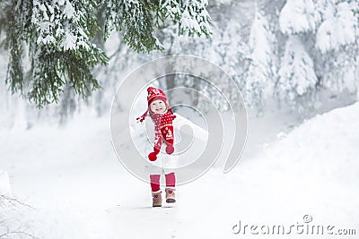 Funny laughing toddler girl running in snowy park