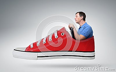 Funny man car driver with a wheel in red sneaker