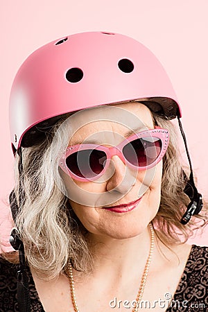 Funny woman wearing Cycling Helmet portrait pink background real