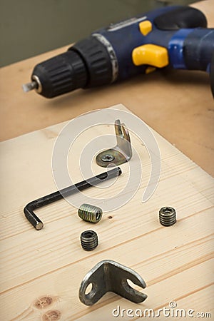 Furniture parts and electric screwdriver on the table