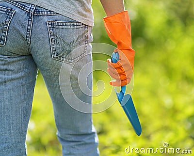 Woman in orange gloves working in the garden