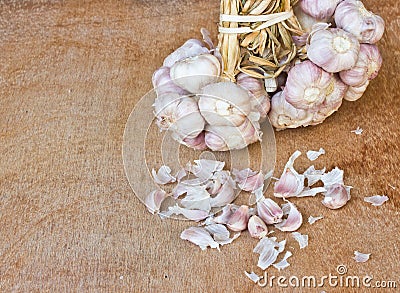 Garlic on brown textured wood.