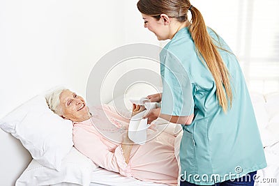 Geriatric nurse washing bedridden
