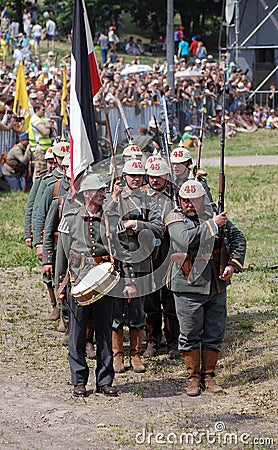 German soldiers-reenactors march with guns.