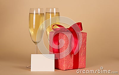 Gift box with a bow, empty card and wine glasses