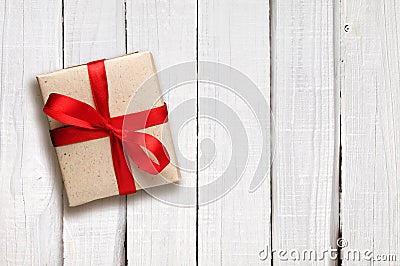 Gift box with red bow on white wood