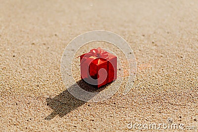 Gift red box on the beach