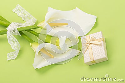 Gift and white lilly flowers on green