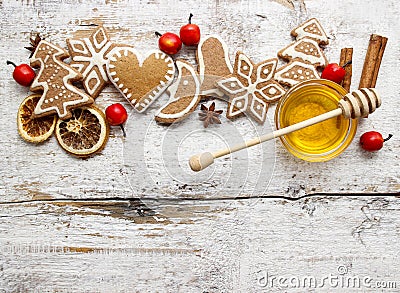 Gingerbread christmas cookies and bowl of honey on wooden table.