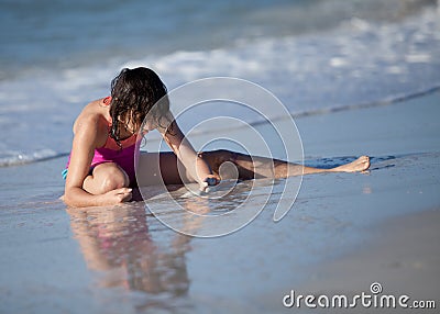 Girl on beach playing in sand