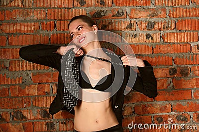 Girl in black suit takes off necktie.