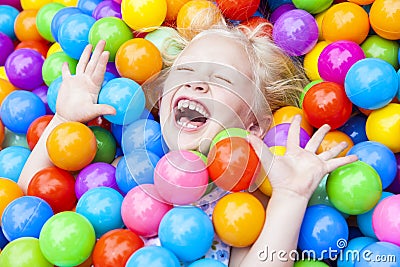 Girl Child Having Fun Playing in Colored Balls