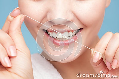 Girl cleaning teeth with dental floss. Health care