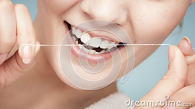 Girl cleaning teeth with dental floss. Health care