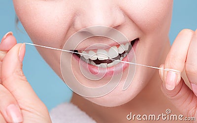 Girl cleaning teeth with dental floss. Health care