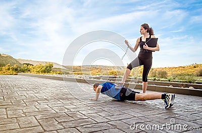 Girl coach training hard a man through push ups