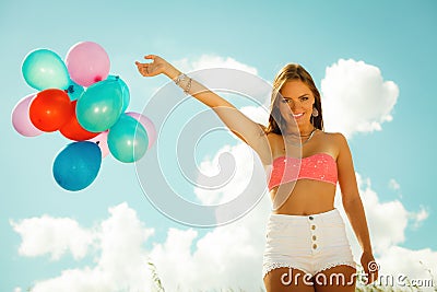 Girl with colorful balloons on beach