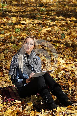 The girl draws in the autumn park