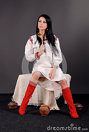 Girl dressed in a white shirt, red belt and red boots