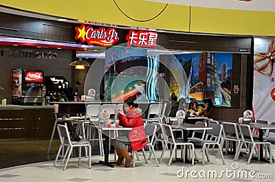 Girl eats at fast food restaurant Shanghai China