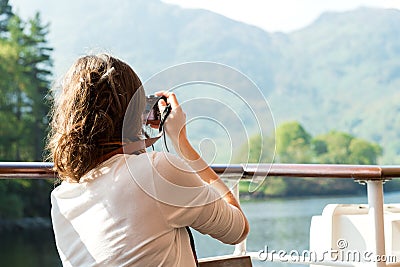 Girl enjoying boat ride, taking photographs