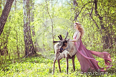 Girl in fairy dress with a flowing train on the dress and reindeer