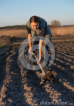 Girl on field work the land at sunset