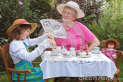Girl and grandmother have a tea party