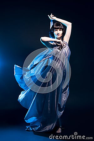 Girl in a gray dress flying on a black