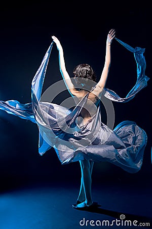 Girl in a gray dress flying with blue backlight