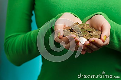 Girl in green turtleneck holding gold coins in hands