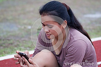 Girl hand touching screen on modern mobile at sports stadium
