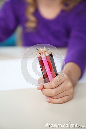 Girl Holding Of Colored Pencils In Classroom