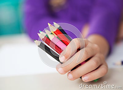 Girl Holding Colored Pencils At Desk