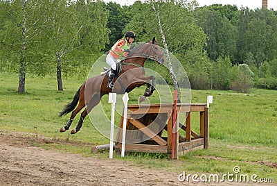 Girl horseback on jumping red chestnut horse