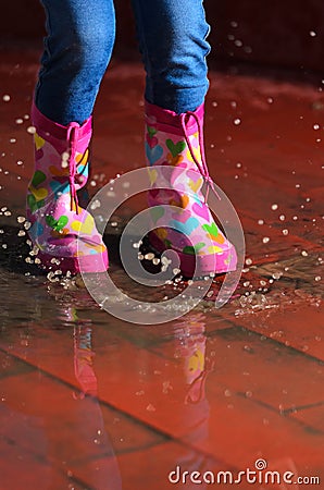 Girl jumping in the puddle