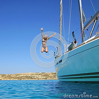 Girl jumping in sea off boat