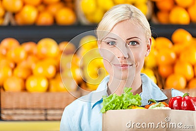 Girl keeps packet with fresh vegetables